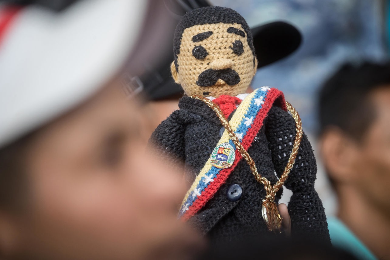 Un seguidor del presidente de Venezuela y candidato a la reelección, Nicolás Maduro, sostiene un muñeco que representa al mandatario en un acto de campaña en Caracas. Foto: Miguel Gutiérrez / EFE.