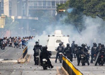 Integrantes de la Policía Nacional Bolivariana (PNB) y la Guardia Nacional Bolivariana (GNB) enfrentan a manifestantes opositores este lunes, durante una protesta contra de los resultados de las elecciones presidenciales, en Caracas. Foto:  Ronald Peña R/EFE.