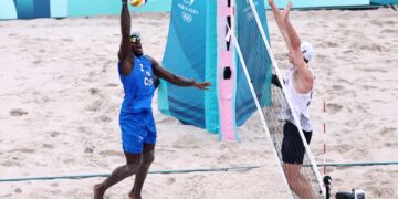 El cubano Jorge Luis Alayo (i) en una acción de juego en el partido de voley de playa en el que Cuba derrotó a Estados Unidos, en su estreno olímpico en París 2024. Foto: Anna Szilagyi / EFE.