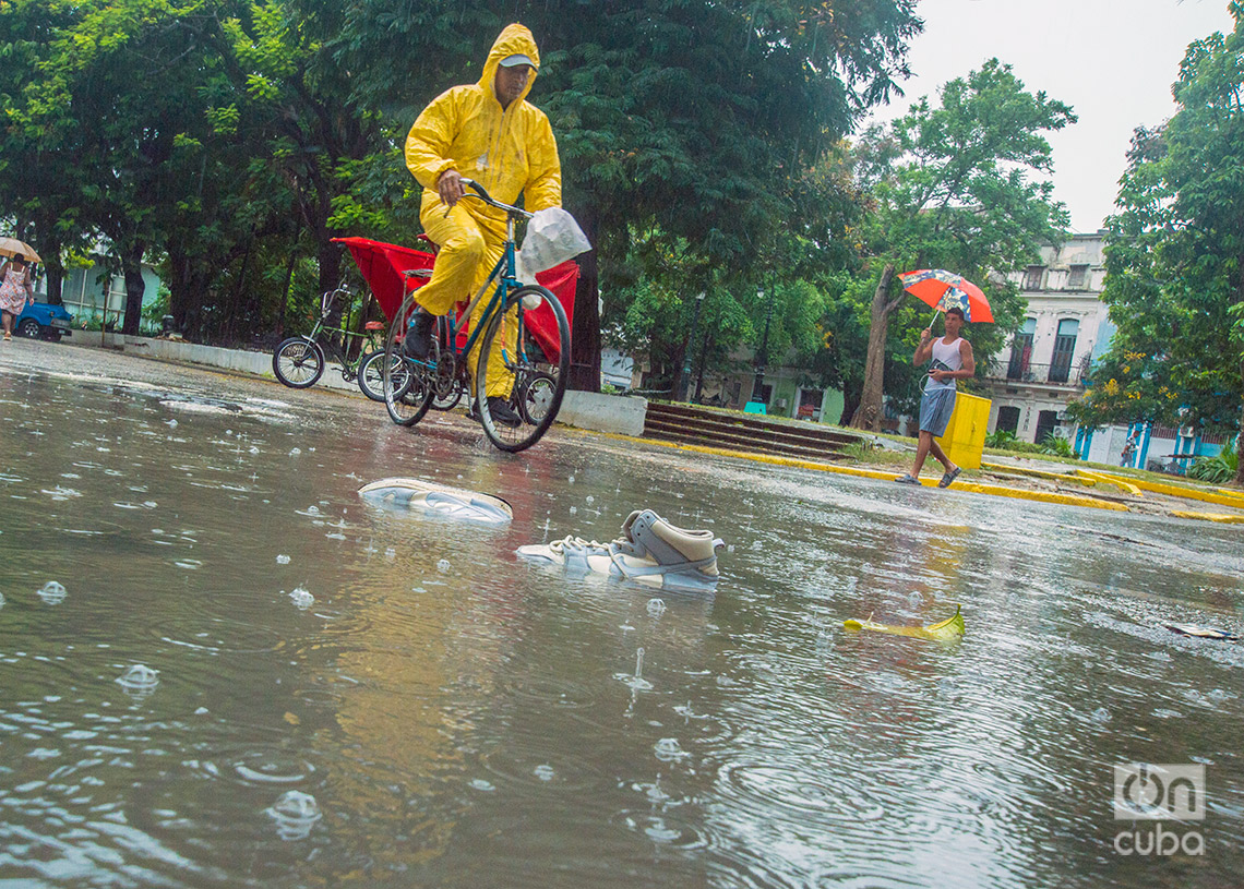Un hombre se traslada en bicicleta en La Habana durante las lluvias de la tormenta Debby. Foto: Otmaro Rodríguez.