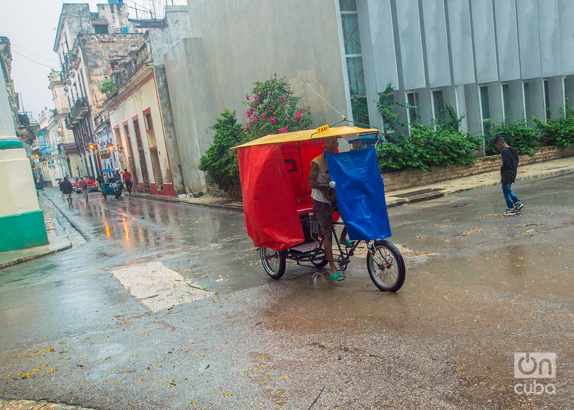 Bicitaxi con protector de nylon durante las lluvias de la tormenta Debby en La Habana. Foto: Otmaro Rodríguez.