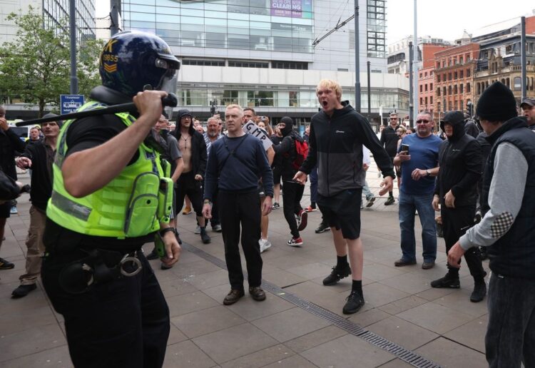 Miembros de los grupos de choque de la ultraderecha en la ciudad de Manchester se enfrentan a la policía. Foto: EFE/EPA/STR