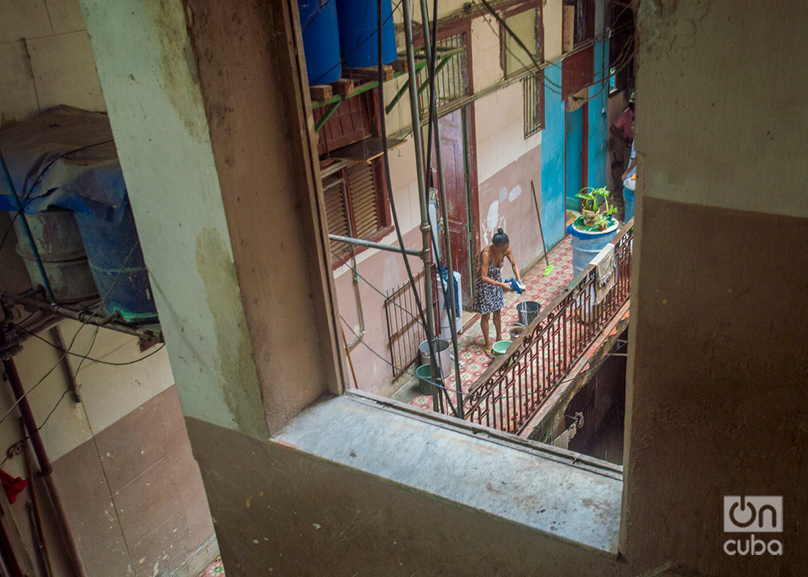 Una mujer aprovecha el agua de la lluvia de la tormenta Debby para lavar, en La Habana. Foto: Otmaro Rodríguez.