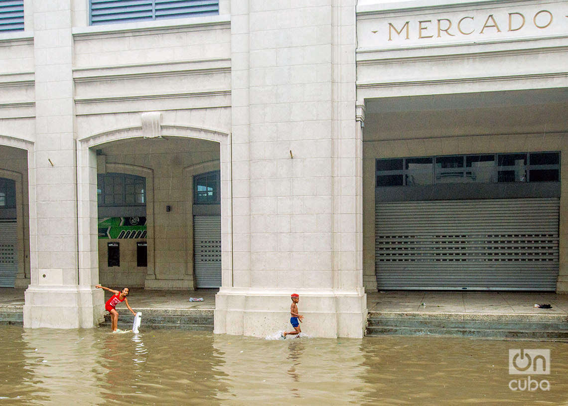 Niños jugando en los alrededores del mercado de Cuatro Caminos, en La Habana, una zona inundada por las lluvias de la tormenta Debby, el 4 de agosto de 2024. Foto: Otmaro Rodríguez.