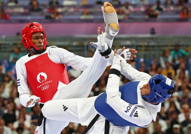 Rafael Alba (rojo) perdió en su segundo combate contra el británico Caden Cunningham (azul), pero avanzó a la discusión de las medallas y ganó un bronce.  Foto: Divyakant Solanki/EFE.