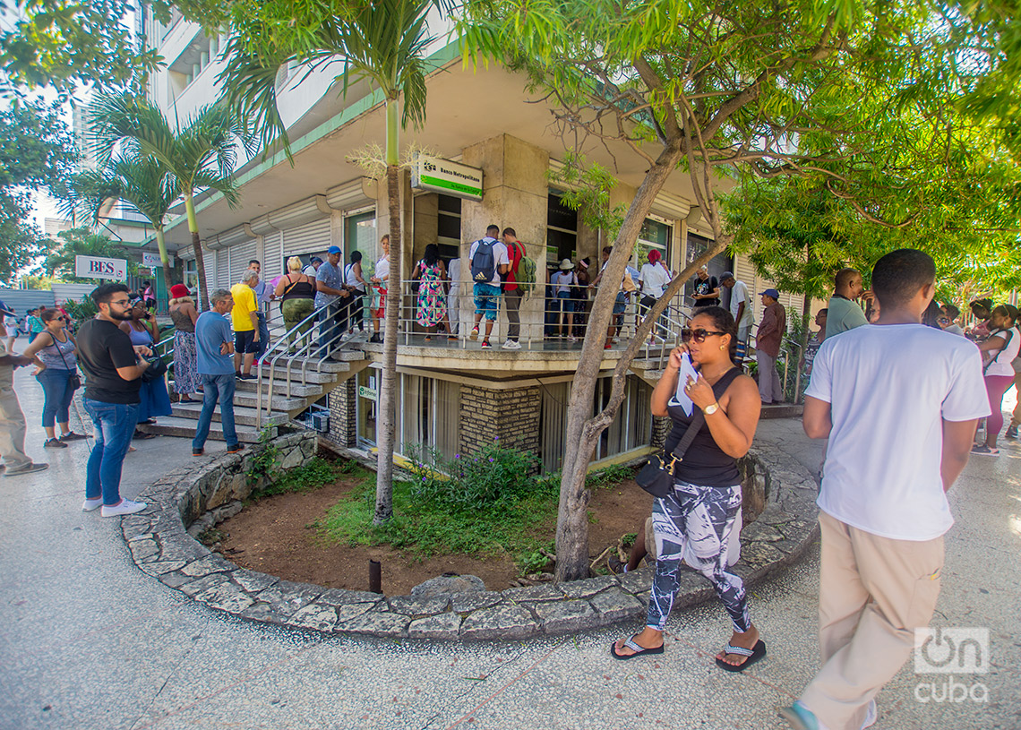 Personas caminan y hacen cola en los alrededores de un banco y cajeros automáticos en el Vedado. Foto: Otmaro Rodríguez.