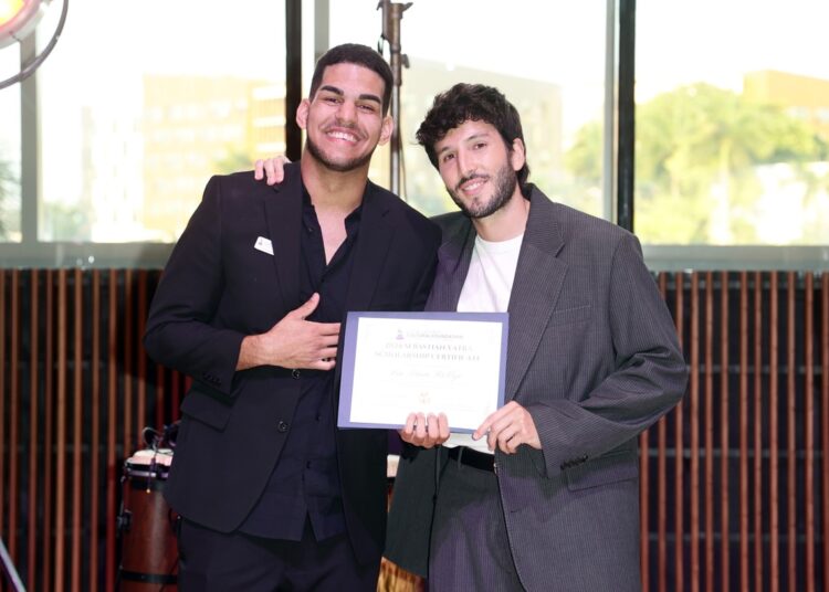 El colombiano colombiano Sebastián Yatra entrega una beca de la Fundación Cultural Latin Grammy al joven contrabajista cubano Leo Luna Roblejo, en Miami, el 7 de agosto de 2024. Foto: Latin GRAMMY Cultural Foundation / Facebook.