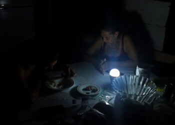 Una mujer conversando con su hijo durante un apagón, en La Habana. Foto: EFE/ Ernesto Mastrascusa ARCHIVO.