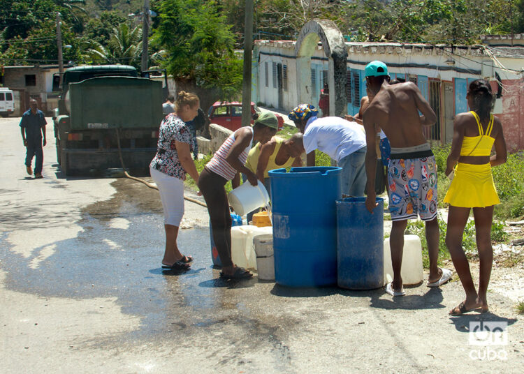 Personas cargan agua desde un camión cisterna (pipa) en La Habana. Foto: Otmaro Rodríguez.