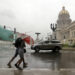 Personas bajo la lluvia en La Habana. Foto: Ernesto Mastrascusa / EFE / Archivo.