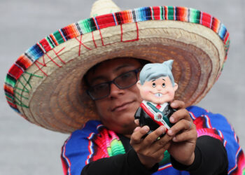 Una persona con un muñeco alusivo al presidente de México, Andrés Manuel López Obrador, asiste a la ceremonia por el 214 aniversario del Grito de independencia, el 16 de septiembre, desde la explanada del Zócalo en Ciudad de México. Foto: EFE/ Mario Guzmán.