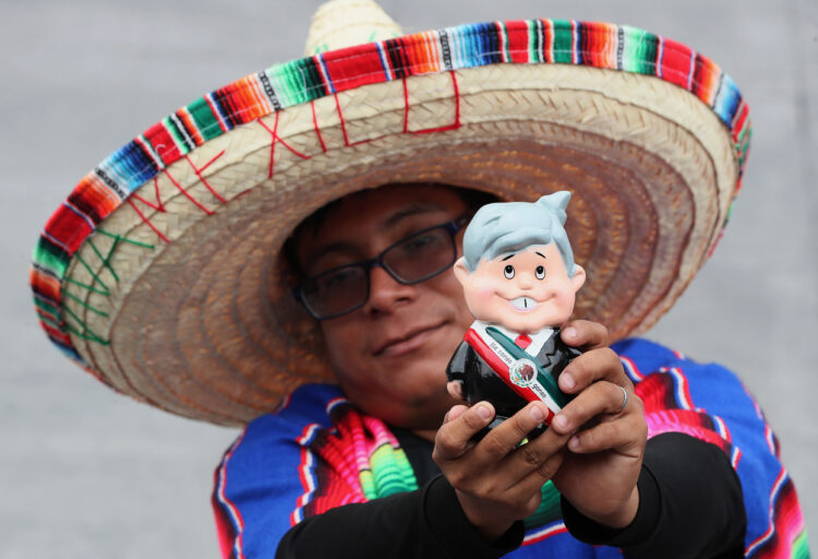 Una persona con un muñeco alusivo al presidente de México, Andrés Manuel López Obrador, asiste a la ceremonia por el 214 aniversario del Grito de independencia, el 16 de septiembre, desde la explanada del Zócalo en Ciudad de México. Foto: EFE/ Mario Guzmán.