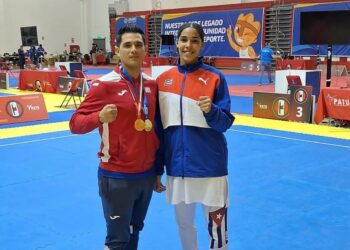 La joven taekwondoca cubana Elianet María Crespo Hernández junto a su entrenador, tras lograr dos títulos en Perú. Foto: Tomada del Facebook del entrenador Arnoy Rojas.