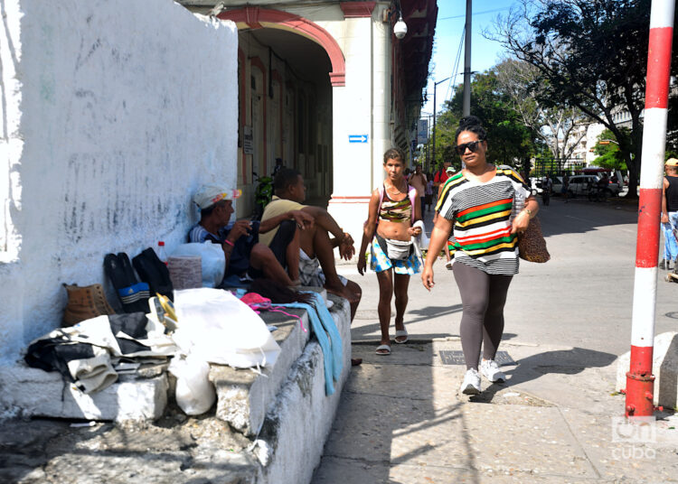 Unas mujeres transitan cerca de unos vendedores callejeros en la calle Reina, en La Habana. Foto: Otmaro Rodríguez.