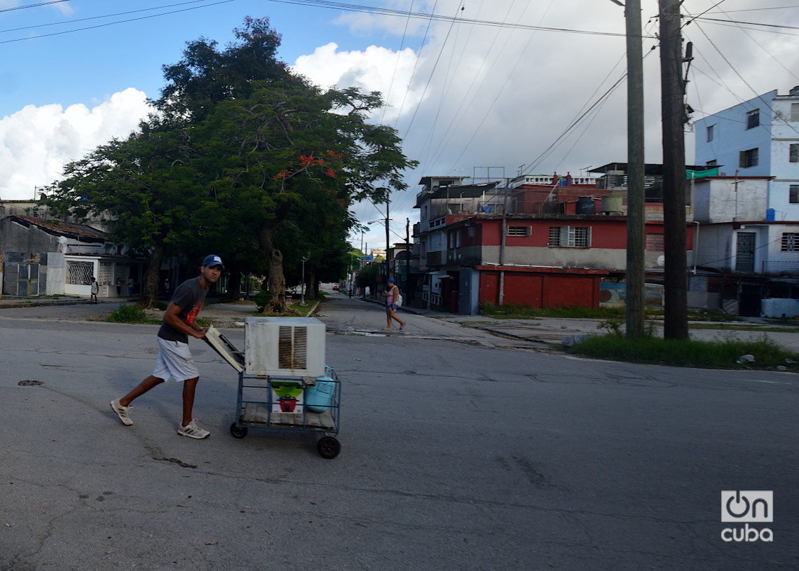 Un joven transporta en una carretilla un aire acondicionado reparto Zamora, Marianao, La Habana. Foto: Otmaro Rodríguez.