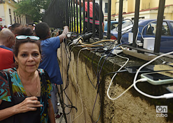 Personas recargan sus teléfonos en La Habana durante el apagón por la desconexión total del sistema eléctrico de Cuba. Foto: Otmaro Rodríguez.