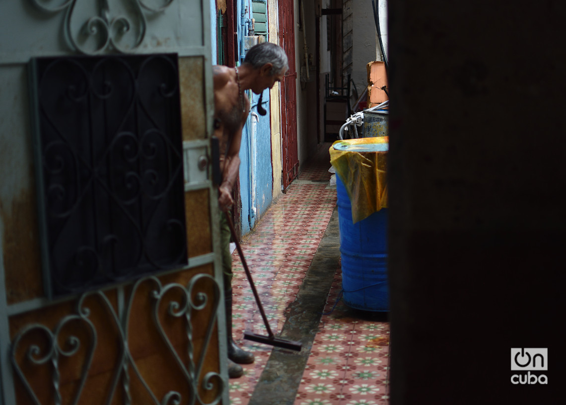 Un hombre limpia su casa en La Habana durante el apagón por la desconexión total del sistema eléctrico de Cuba. Foto: Otmaro Rodríguez.