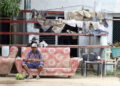 Un hombre descansa en el exterior de una vivienda en la región de San Antonio del Sur una semana después del paso de la tormenta tropical Oscar. Foto: Ernesto Mastrascusa / POOL / EFE.