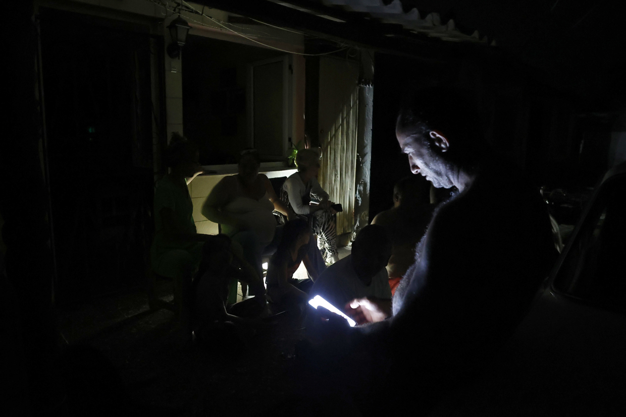 Personas en La Habana durante durante el apagón por la desconexión total del sistema eléctrico de Cuba. Foto: Ernesto Mastrascusa / EFE.