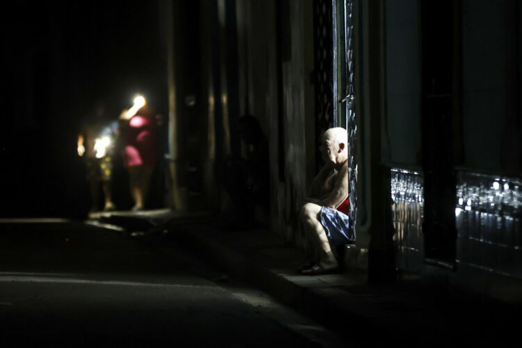 Personas de noche en una calle de La Habana durante durante el apagón por la desconexión total del sistema eléctrico de Cuba. Foto: Ernesto Mastrascusa / EFE.