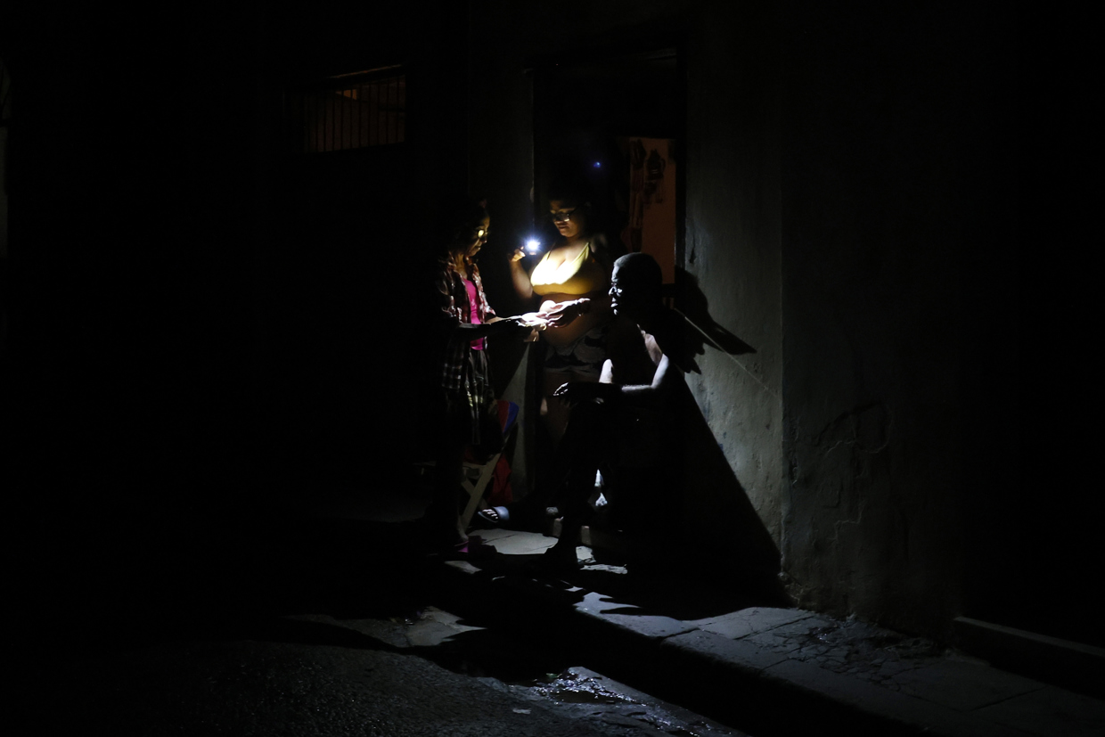 Personas en La Habana durante durante el apagón por la desconexión total del sistema eléctrico de Cuba. Foto: Ernesto Mastrascusa / EFE.