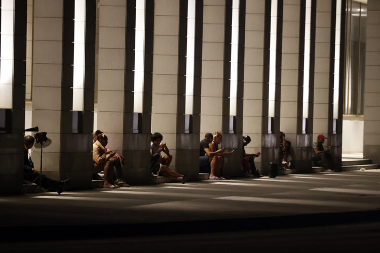 Personas revisan sus teléfonos celulares en el portal de un hotel con electricidad por sus plantas eléctricas, durante el apagón en La Habana por la desconexión del Sistema Electroenergético de Cuba. Foto: Ernesto Mastrascusa / EFE.