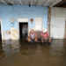 Personas descansan frente a casas afectadas por las inundaciones provocadas por el huracán Milton en Batabanó, en la costa sur del occidente de Cuba. Foto: Ernesto Mastrascusa / EFE.