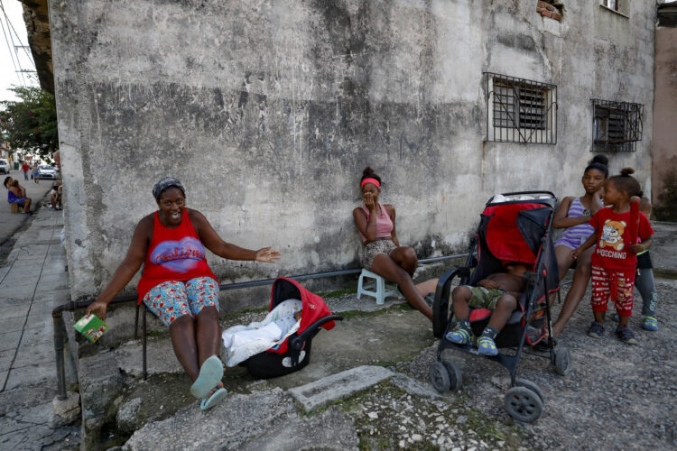 Personas descansando afuera de sus casas durante la caída del SEN, que apagó toda la isla desde el viernes. Foto: Yander Zamora/EFE.