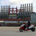 Un hombre en una moto eléctrica pasa frente a una de las plantas de generación eléctrica que permanece este domingo, en el puerto de La Habana Foto: EFE/ Ernesto Mastrascusa