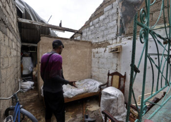 Un hombre observa los daños causados en su vivienda por el huracán Rafael, en Artemisa. Foto: Ernesto Mastrascusa / EFE.