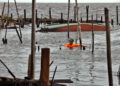 Un pescador nada en el agua tras el paso del huracán Rafael, en Playa Majana, en la provincia de Artemisa. Foto: Ernesto Mastrascusa / EFE.