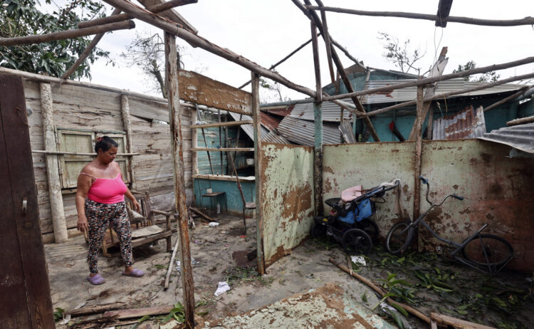 Una mujer observa su vivienda destrozada por el huracán Rafael, en Artemisa. Foto: Ernesto Mastrascusa / EFE.