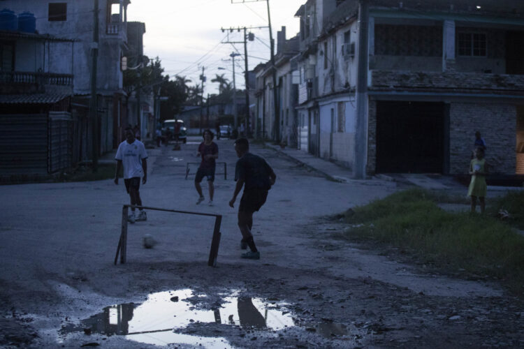 Jóvenes juegan fútbol durante un apagón, en el Cerro, La Habana. Foto:  Yander Zamora / EFE.