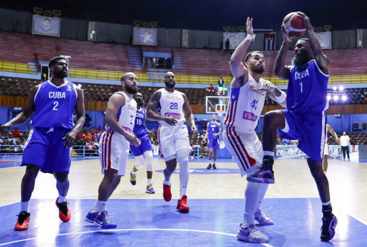 El cubano Reynaldo Garcia disputa un balón con el puertorriqueño Arnaldo Toro en el partido de clasificación a la FIBA Americup 2025. Foto: Ernesto Mastrascusa/EFE