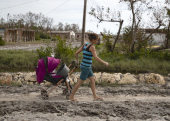 Una mujer arrastra un coche de bebé por una de las calles de playa Guanimar, uno de los sitios afectados por el paso del huracán Rafael, el 20 de noviembre de 2024 en Artemisa. Foto: Yander Zamora / EFE.