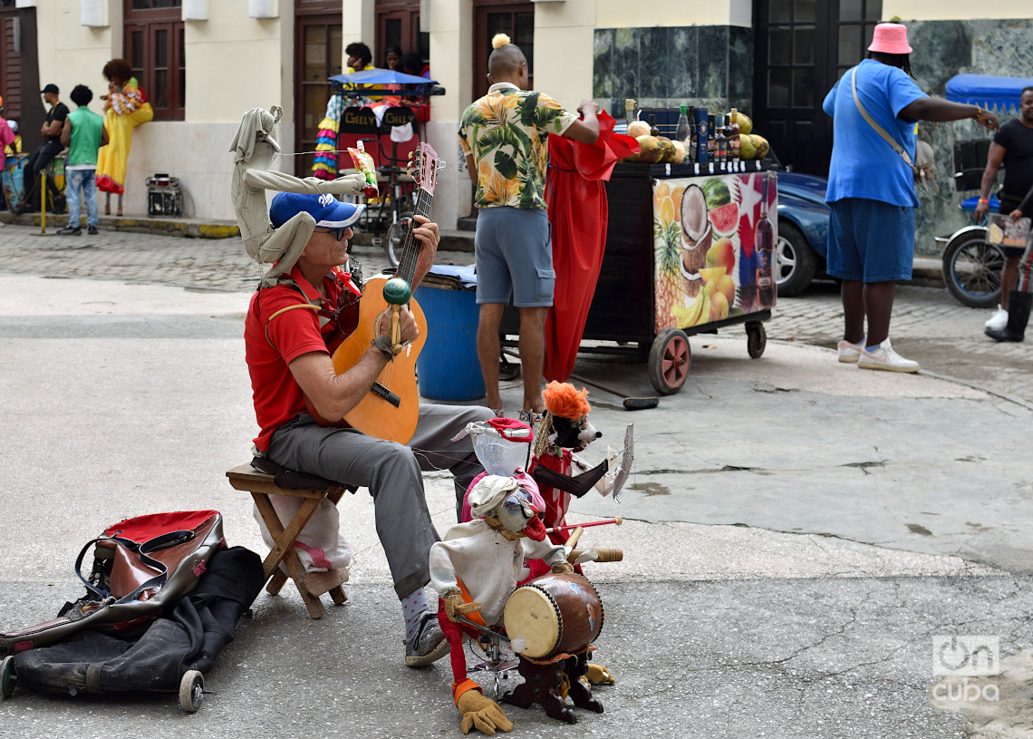 Un músico callejero y un vendedor particular en La Habana, el último fin de semana de 2024. Foto: Otmaro Rodríguez.