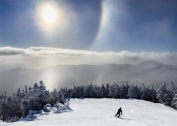 Los cristales de hielo en el aire forman un halo solar sobre el monte Mansfield mientras un esquiador desciende por la ladera en Stowe, Vermont, EE. UU., el 22 de diciembre de 2024. Foto: JIM LO SCALZO /EFE/EPA.