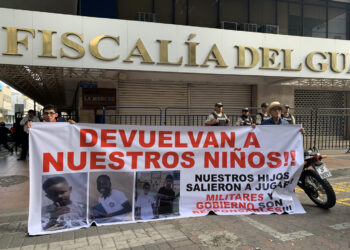 Dos personas sostienen un cartel en los exteriores de la Fiscalía Provincial del Guayas con el mensaje "devuelvan a nuestros niños", en alusión a los cuatro menores desaparecidos el 8 de diciembre en Guayaquil, Ecuador. Foto: Cristina Bazán / EFE.