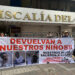 Dos personas sostienen un cartel en los exteriores de la Fiscalía Provincial del Guayas con el mensaje "devuelvan a nuestros niños", en alusión a los cuatro menores desaparecidos el 8 de diciembre en Guayaquil, Ecuador. Foto: Cristina Bazán / EFE.