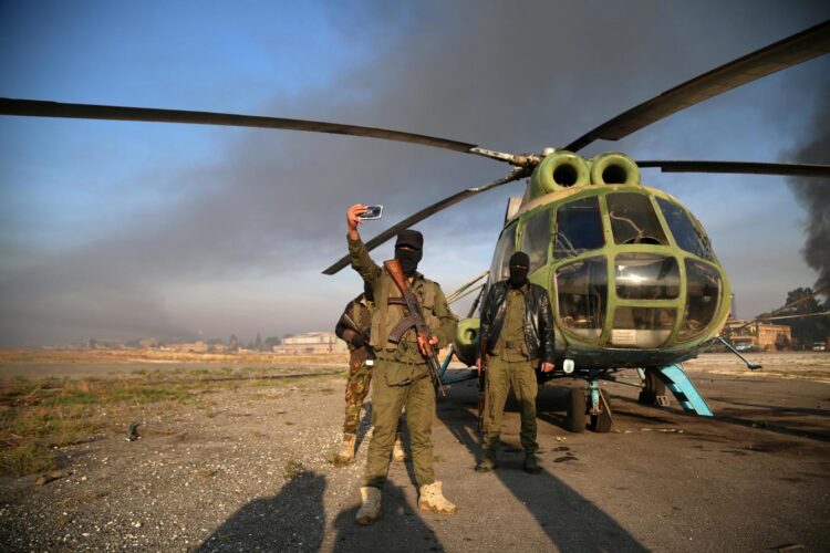 Hombres armados se toman selfies en el aeropuerto militar de Nayrab, en Alepo, Siria, el 2 de diciembre de 2024. Foto: BILAL AL HAMMOUD/EFE/EPA.