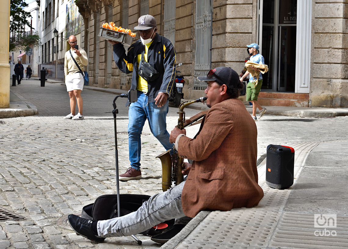 Un músico callejero y un vendedor de chiviricos, en el centro histórico de La Habana, en los primeros días de 2025. Foto: Otmaro Rodríguez.