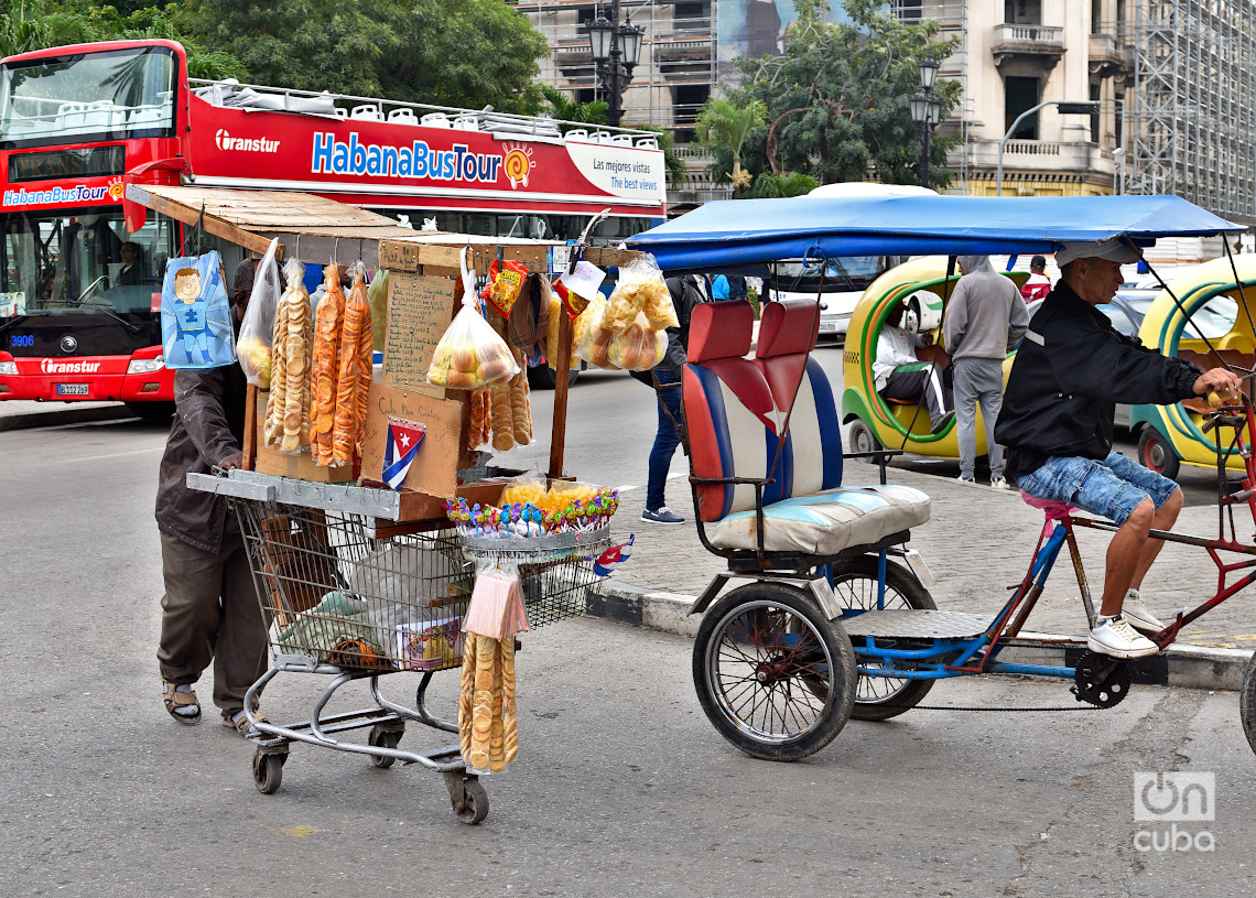 Un vendedor ambulante y un bicitaxi en La Habana durante un frente frío. Foto: Otmaro Rodríguez.