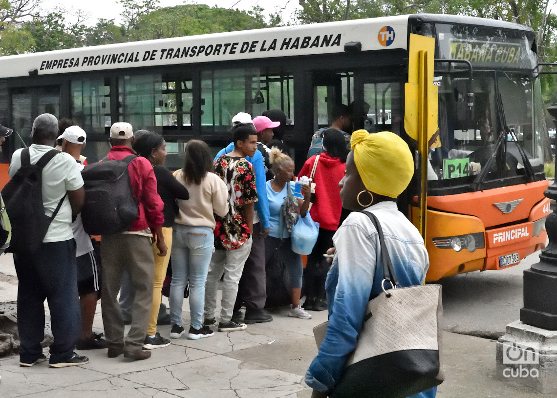 Personas hacen cola para abordar un ómnibus en La Habana durante un frente frío. Foto: Otmaro Rodríguez.