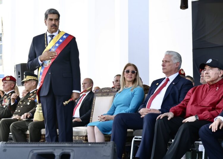 El presidente cubano Miguel Díaz-Canel asiste a un acto en Venezuela, luego de la toma de posesión de su homólogo venezolano Nicolás Maduro (de pie), junto al mandatario nicaragüense Daniel Ortega, la primera dama venezolana Cilia Flores y otros asistentes. Foto: Presidencia Cuba / X.