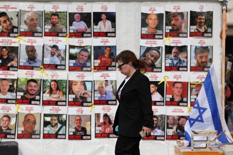 Una mujer pasa junto a una exposición imágenes de los rehenes israelíes secuestrados durante los ataques de Hamás a Israel del 7 de octubre de 2023, frente al cuartel general militar de Kirya en Tel Aviv, Israel, el 17 de enero de 2025. Foto: Abir Sultan / EFE.