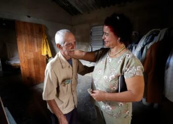 Un anciano que vive solo conversa con una trabajadora del Centro Cristiano de Reflexión y Diálogo (CCRD), en Cárdenas, Matanzas. Foto: Ernesto Mastrascusa / EFE.