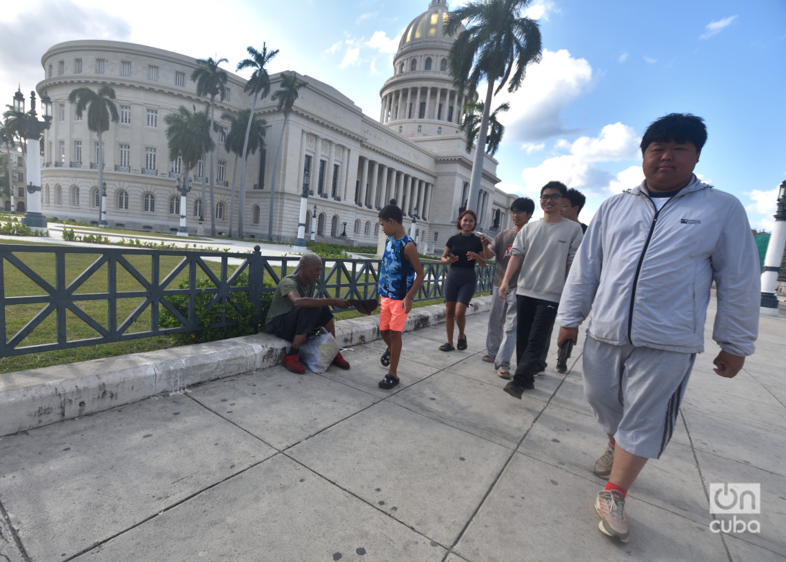 Una persona pide dinero a turistas cerca del Capitolio de La Habana. Foto: Otmaro Rodríguez.